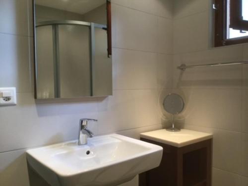 a white bathroom with a sink and a mirror at Chalet Chouc'le in Vercorin