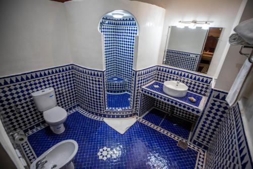 a blue and white bathroom with a shower and a sink at Riad Dilar Fes & Spa in Fès