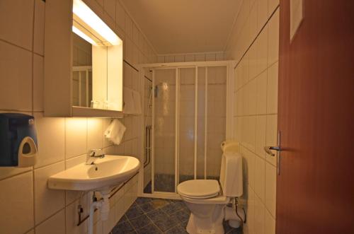 a bathroom with a toilet and a sink at Reisafjord Hotel in Sørkjosen