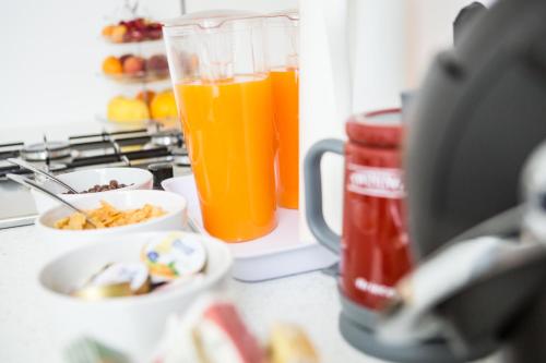 Rhegion B&B في ريجّو دي كالابريا: كوب من عصير البرتقال يجلس على منضدة مع الطعام