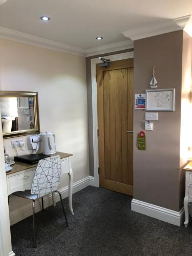 a room with a desk and a refrigerator at Queen Phillippa in Queenborough