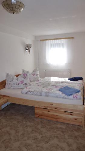 a bed with a wooden frame in a room with a window at Ferienwohnung Rasch in Schierke