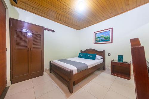 a bedroom with a bed and a wooden ceiling at Ayenda Pakande in Popayan