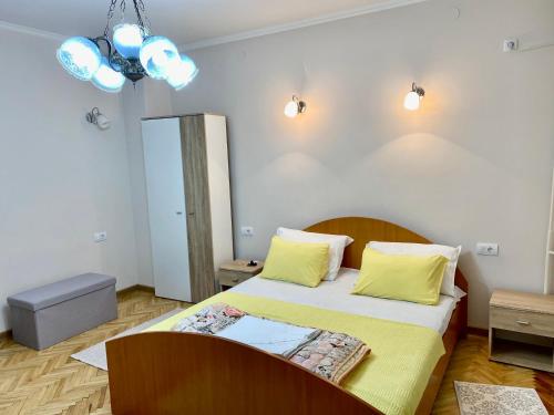 a bedroom with a large bed with yellow pillows at Apartment "JONA " in Niš