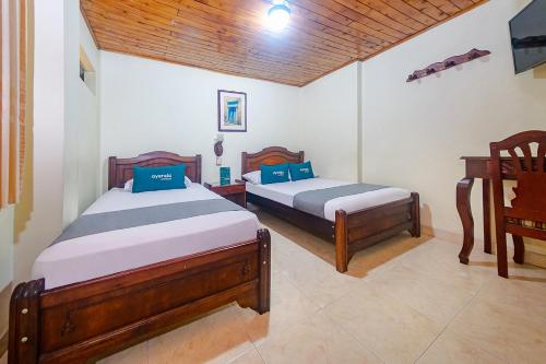 a bedroom with two beds and a piano at Ayenda Pakande in Popayan