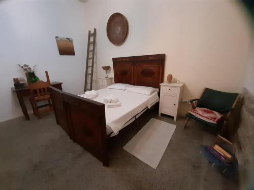 ein Schlafzimmer mit einem großen Bett und einem Stuhl in der Unterkunft Domu Odilia in Serrenti