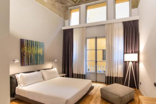 a bedroom with a bed and a large window at The Charm of Santa Croce in Florence