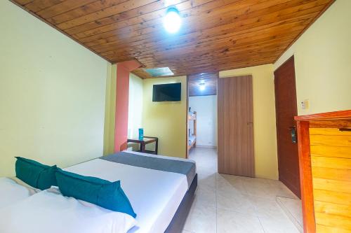 a bedroom with a white bed and a wooden ceiling at Ayenda Pakande in Popayan