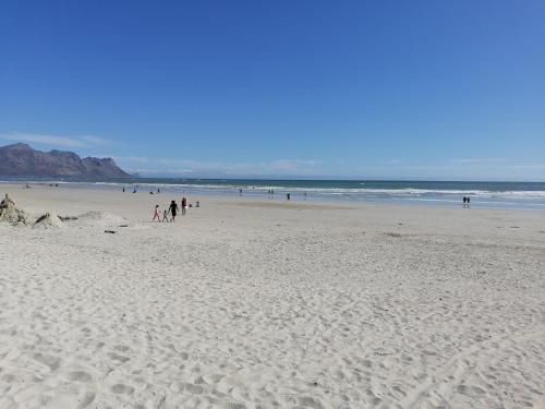 a group of people walking on a beach at The Jade Somerset West in Cape Town