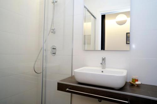 y baño blanco con lavabo y ducha. en Loaldia, en San Sebastián