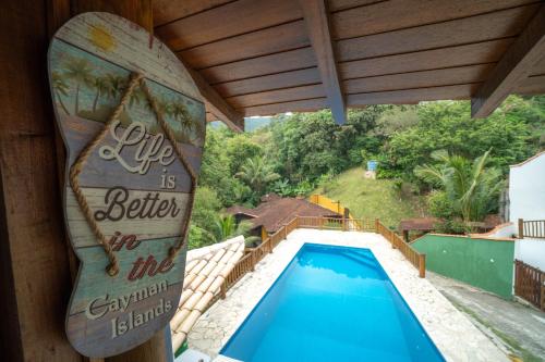 a swimming pool with a sign on the side of a house at Diver Village Ilhabela in Ilhabela