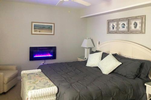 a bedroom with a bed and a flat screen tv at Charming Oceanfront Condo, Walk to Wildwood Beach in Wildwood Crest