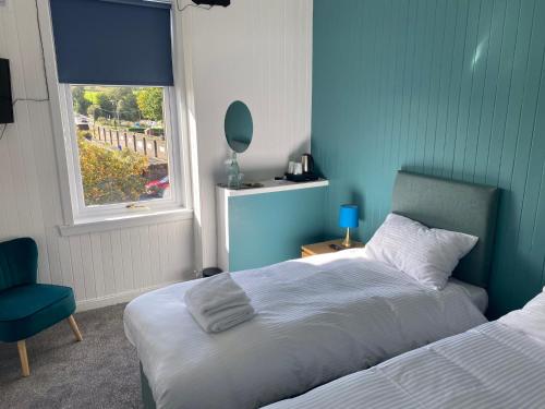 1 dormitorio con 1 cama, 1 silla y 1 ventana en Queensberry arms hotel, en Kirkconnel