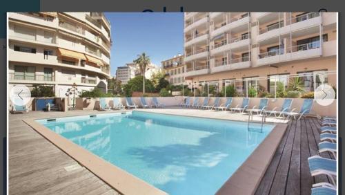 une grande piscine avec des chaises et un bâtiment dans l'établissement SOPHIES HOMES FÉLIBRIGES BEACH & PALAIS des FESTIVALS, à Cannes