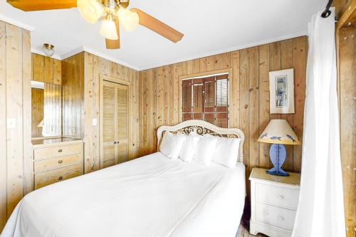 a bedroom with a white bed and a ceiling fan at Hakuna Matata in Gulf Shores