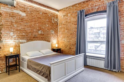 ロストフ・ナ・ドヌにあるNabokov Loft-Hotelのレンガの壁、ベッド付きのベッドルーム1室