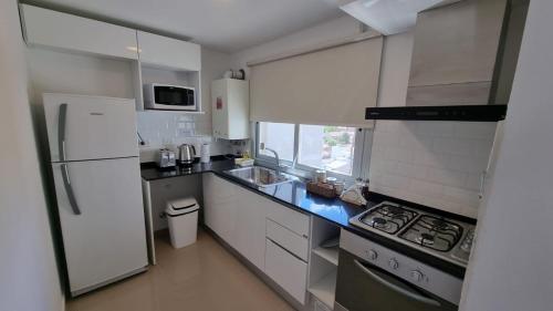 eine Küche mit einem weißen Kühlschrank und einem Herd in der Unterkunft Comfort Patagonia Inn in Neuquén