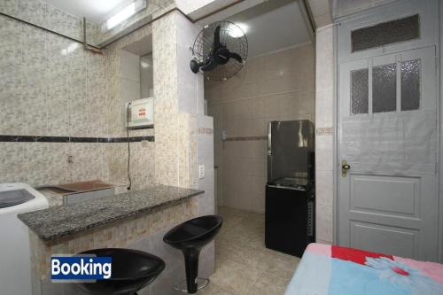 a kitchen with a black refrigerator and a black stool at Apartamento Botafogo in Rio de Janeiro