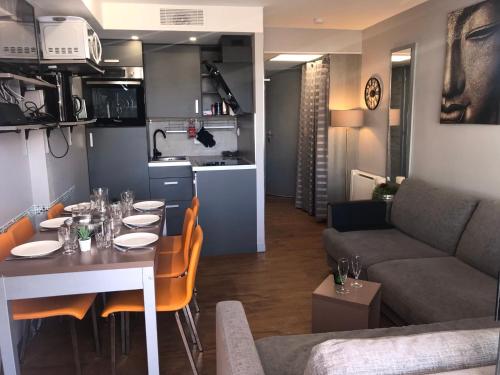 Il dispose d'une cuisine et d'un salon avec une table et un canapé. dans l'établissement SOPHIES HOMES FÉLIBRIGES BEACH & PALAIS des FESTIVALS, à Cannes