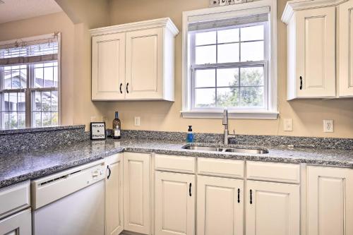 a kitchen with white cabinets and a sink at Bright and Airy Resort Condo Golf, Shop and Swim in North Myrtle Beach