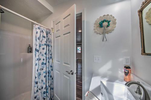 ein Badezimmer mit einer Badewanne, einem Waschbecken und einem Spiegel in der Unterkunft Pet-Friendly Libby Cottage with Mountain Views! in Libby