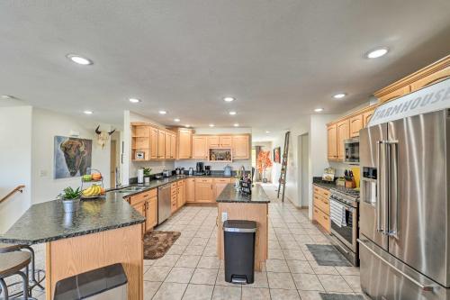 a large kitchen with wooden cabinets and stainless steel appliances at Outdoor Enthusiasts Retreat with Hot Tub, Deck in Lander
