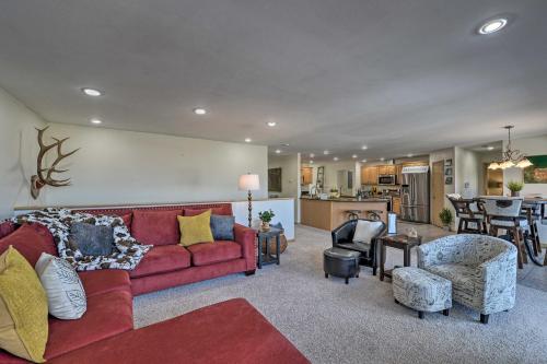 a living room with a red couch and a kitchen at Outdoor Enthusiasts Retreat with Hot Tub, Deck in Lander