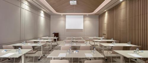a large room with tables and chairs and a projection screen at Melas Hotel Istanbul in Istanbul