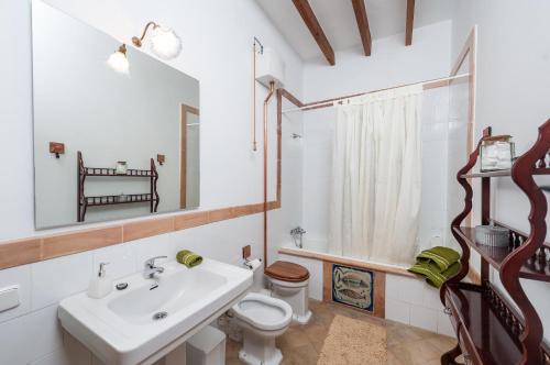Baño blanco con lavabo y aseo en YupiHome Holiday Home Ca Na Blan ca, en Alcudia
