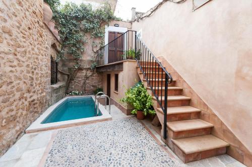 a house with a swimming pool next to a stairs at YupiHome Holiday Home Ca Na Blan ca in Alcudia