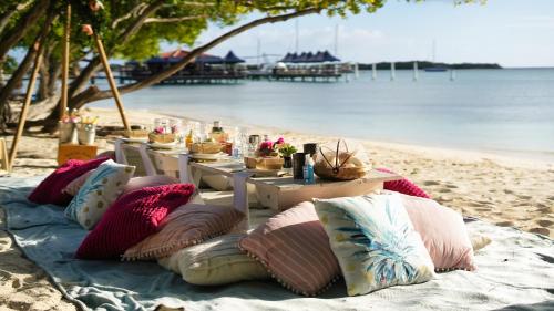 a table with pillows on a sandy beach at Villa Aloe in Paradijs