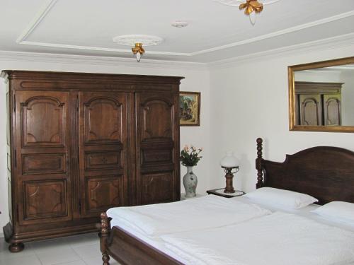 a bedroom with a wooden bed and a large wooden cabinet at Apartment Storchenfärbe in Memmingen