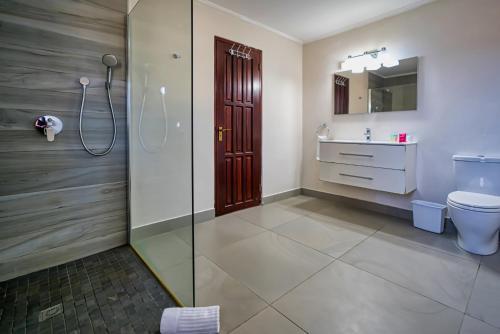 a bathroom with a shower and a toilet and a sink at Villa Bubali Escape in Palm-Eagle Beach