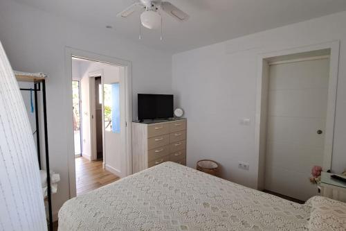 a bedroom with a bed and a television on a dresser at Casa con encanto junto a la playa de La Puntilla in El Puerto de Santa María