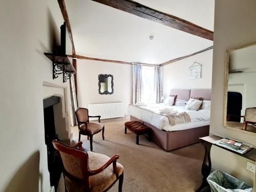 a bedroom with a bed and a fireplace and a mirror at The Harvard Inn in Stock