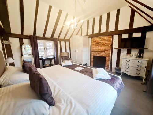 a bedroom with two beds and a fireplace at The Harvard Inn in Stock