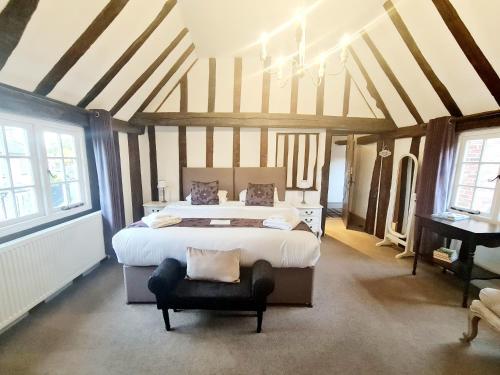 a large bedroom with a large bed and a piano at The Harvard Inn in Stock