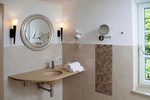 a bathroom with a sink and a mirror at Hotel Zum Schlössle in Finningen