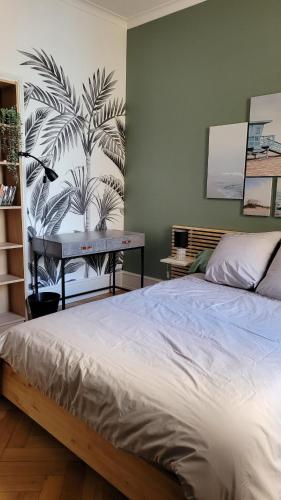 - une chambre avec un lit et une table avec une plante sur le mur dans l'établissement COLMAR Centre VILLE 6 couchages 3 grandes chambres, à Colmar