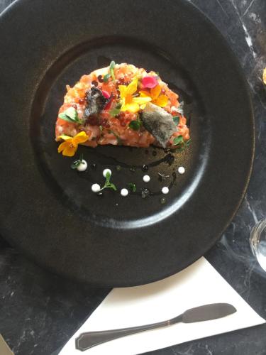 a black plate with a piece of pizza on it at Kyriad Prestige Mulhouse - Basel in Sausheim