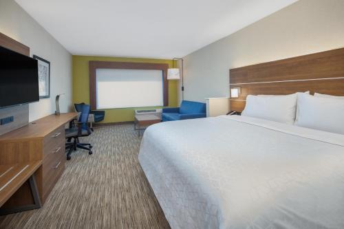 チコにあるHoliday Inn Express & Suites - Chico, an IHG Hotelのベッド1台、薄型テレビが備わるホテルルームです。