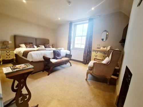a bedroom with a bed and a chair and a table at The Harvard Inn in Stock