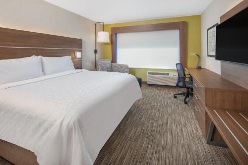 um quarto de hotel com uma cama e uma televisão de ecrã plano em Holiday Inn Express & Suites - Chico, an IHG Hotel em Chico