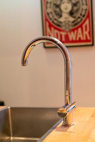 - un évier de cuisine avec un robinet en cuivre sur un comptoir dans l'établissement L'ATELIER DU CHAPEAU ROUGE EN PLEIN CENTRE VILLE, à Dijon