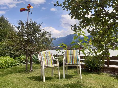 two chairs sitting in the grass next to a fence at Ferienwohnung Frieda in Sillian