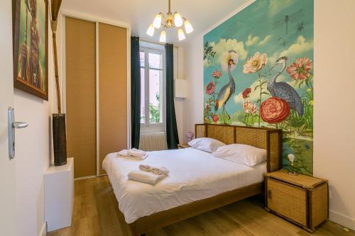 a bedroom with a bed with a painting on the wall at Le DAILY PAINTING plongée dans les années sixties in Dijon