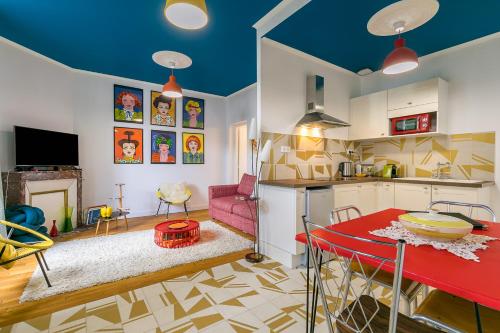 Il comprend une cuisine et un salon avec une table rouge. dans l'établissement Le DAILY PAINTING plongée dans les années sixties, à Dijon