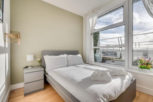 ein weißes Schlafzimmer mit einem Bett und einem Fenster in der Unterkunft Central Belfast Apartments: Park Avenue in Belfast