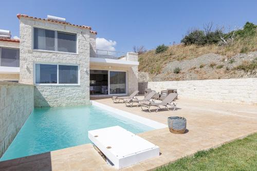 a villa with a swimming pool and a house at Mythos villas in Damnoni