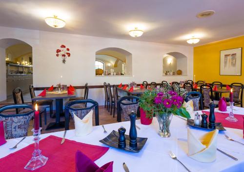 a dining room with tables and chairs with red napkins at Hotel & Ferienwohnungen Bohlenblick in Saalfeld